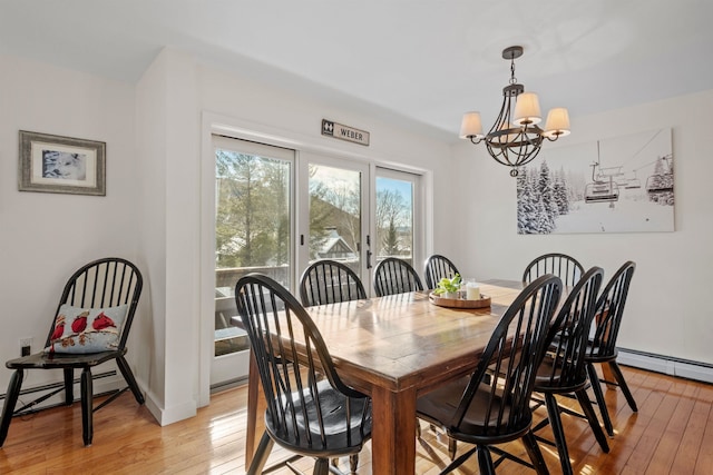 dining space with a chandelier, light hardwood / wood-style floors, and baseboard heating