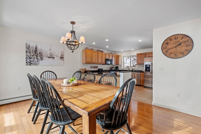 dining space featuring a baseboard radiator, a chandelier, and light wood-type flooring