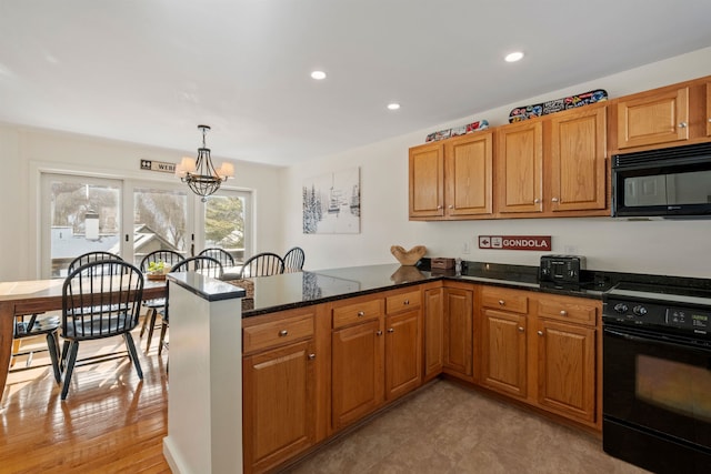 kitchen with decorative light fixtures, black appliances, kitchen peninsula, and dark stone counters