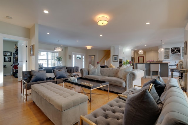 living room with a notable chandelier and light wood-type flooring