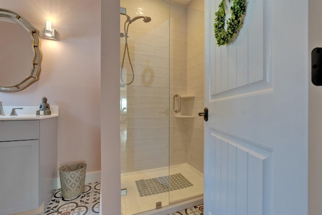 bathroom featuring a shower with door, vanity, and tile patterned floors