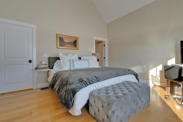 bedroom with high vaulted ceiling and light hardwood / wood-style floors