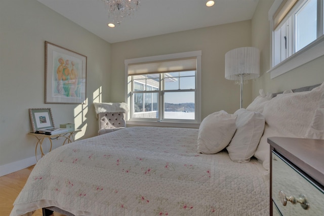 bedroom with light hardwood / wood-style flooring and a notable chandelier