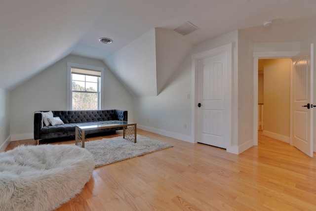 living area featuring lofted ceiling and light wood-type flooring