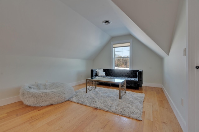 sitting room featuring lofted ceiling and light wood-type flooring