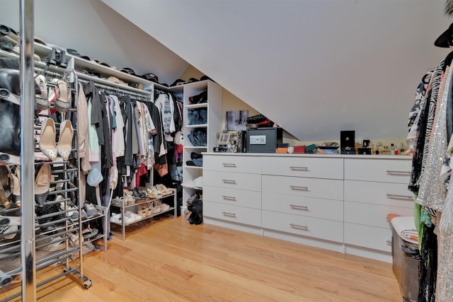 spacious closet with lofted ceiling and light hardwood / wood-style floors