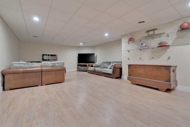 living room featuring a paneled ceiling and light wood-type flooring