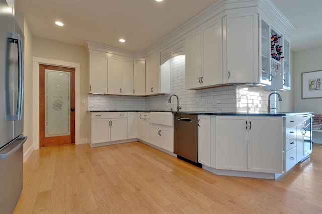 kitchen with light wood-type flooring, stainless steel appliances, sink, and white cabinets