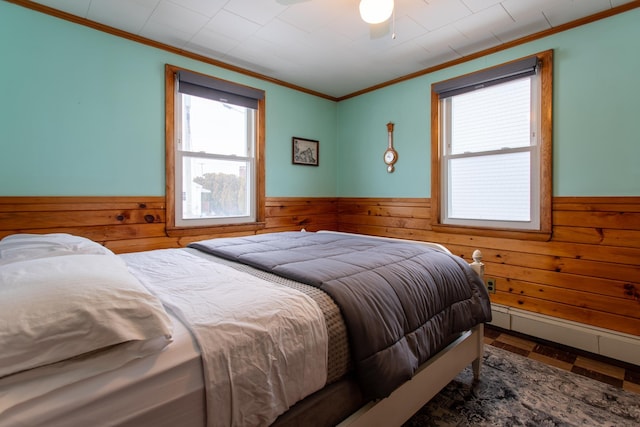 bedroom with crown molding, ceiling fan, and wood walls