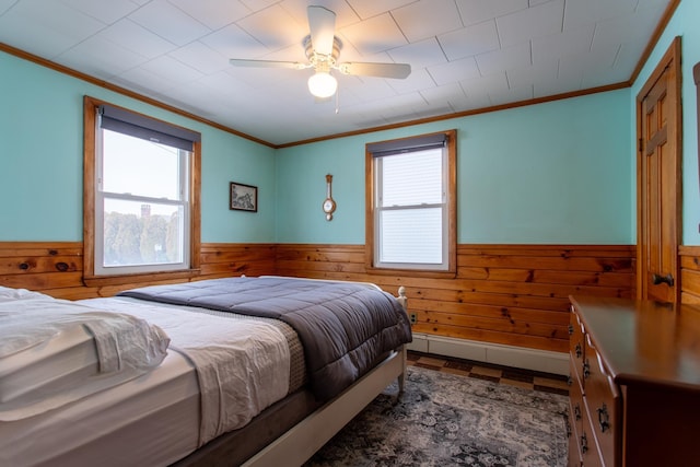 bedroom featuring crown molding, ceiling fan, and wood walls