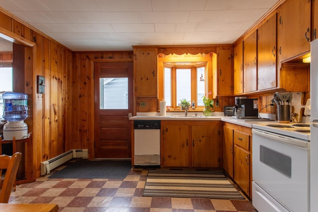 kitchen featuring sink, wood walls, a baseboard radiator, dishwashing machine, and white range with electric stovetop