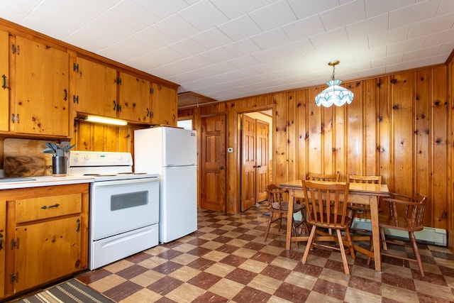 kitchen featuring white appliances, wooden walls, and decorative light fixtures