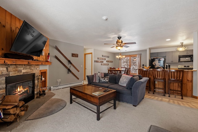 living room featuring a stone fireplace, light carpet, a textured ceiling, and baseboard heating