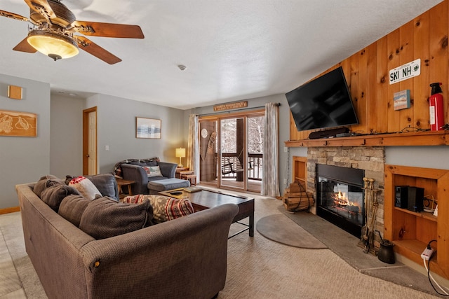 living room featuring a stone fireplace, light colored carpet, and ceiling fan