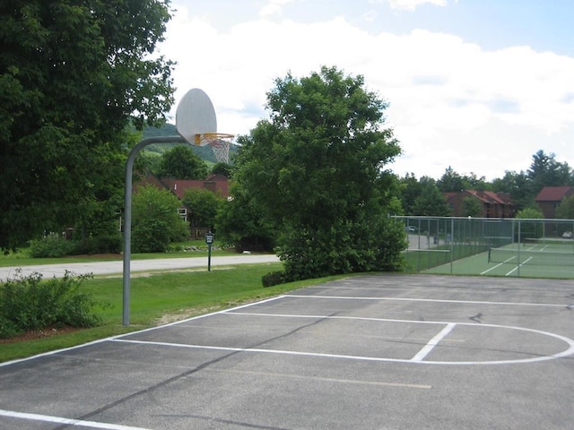 exterior space with tennis court and a lawn