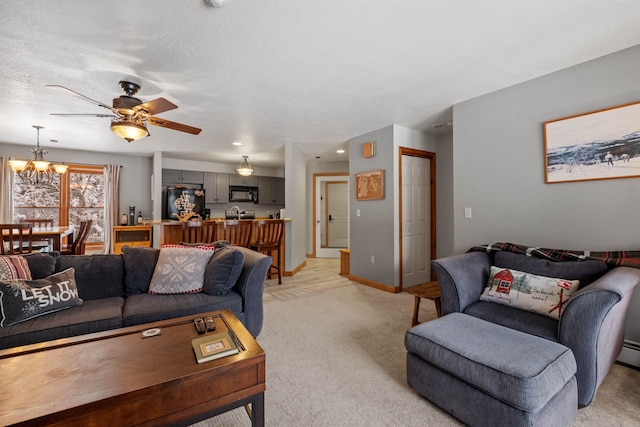 living room featuring ceiling fan with notable chandelier and light colored carpet