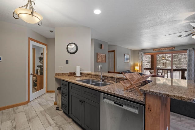 kitchen featuring sink, dishwasher, stone counters, light hardwood / wood-style floors, and a textured ceiling