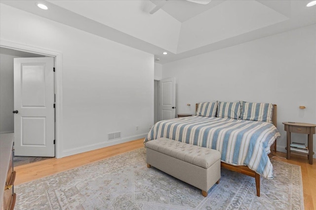 bedroom featuring a raised ceiling and wood-type flooring