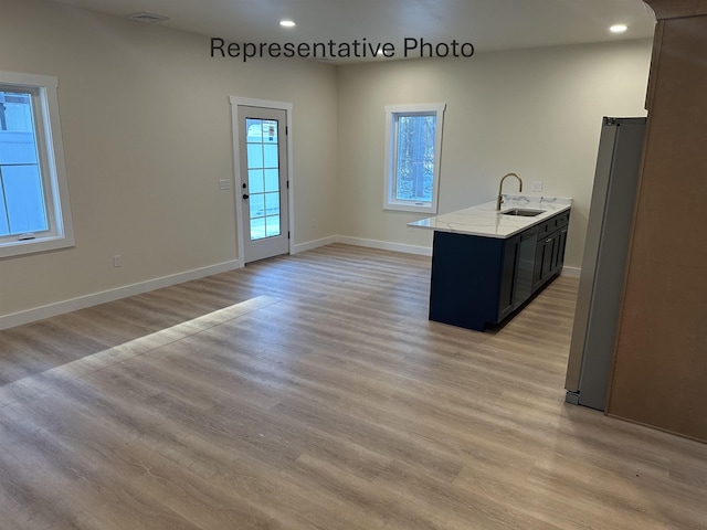 kitchen featuring light hardwood / wood-style flooring, sink, and stainless steel fridge