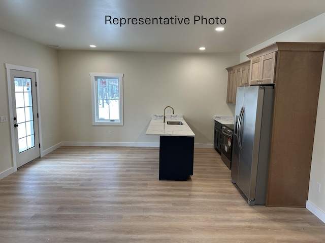 kitchen with stainless steel refrigerator with ice dispenser, sink, a wealth of natural light, and light hardwood / wood-style floors