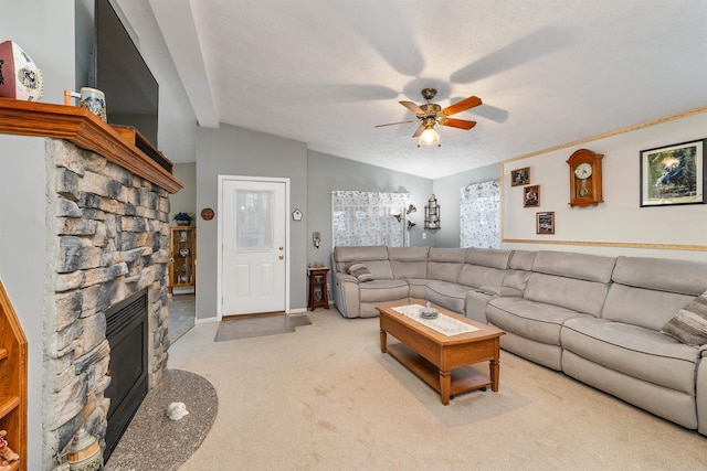 carpeted living room featuring vaulted ceiling, a stone fireplace, and ceiling fan