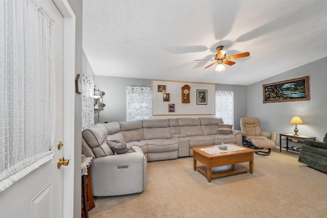 carpeted living room featuring ceiling fan, lofted ceiling, and a textured ceiling