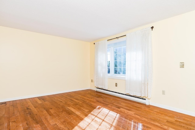 empty room with a baseboard radiator and light wood-type flooring