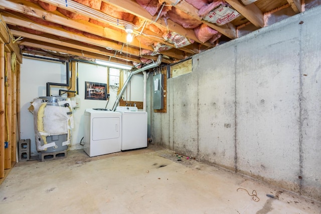 basement featuring washing machine and clothes dryer and electric panel