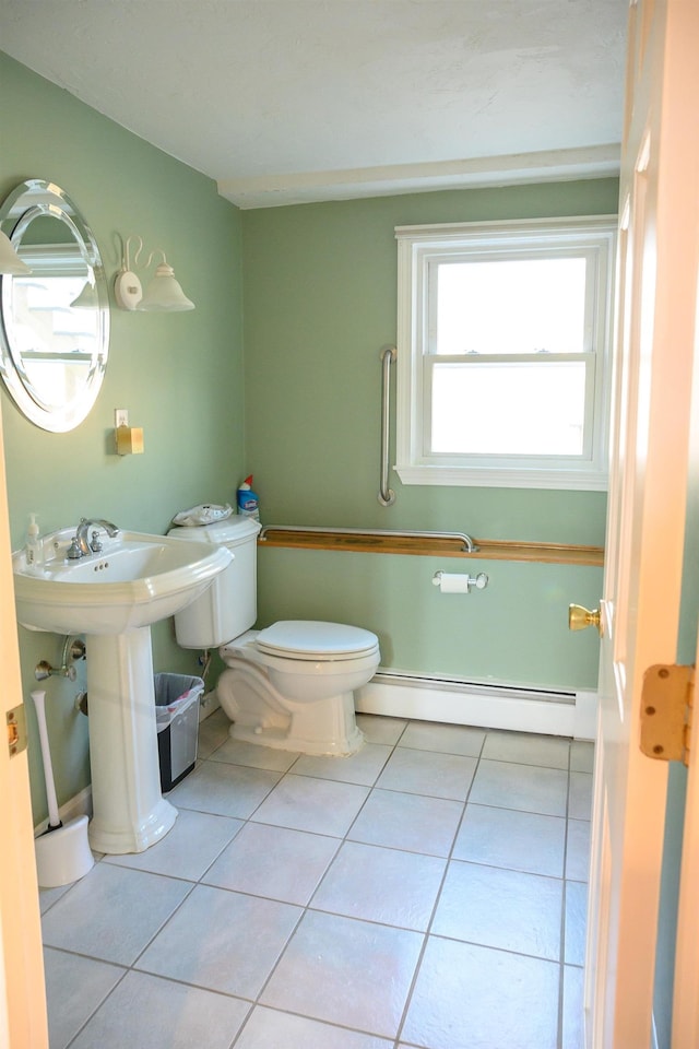 bathroom featuring a baseboard heating unit, tile patterned floors, and toilet