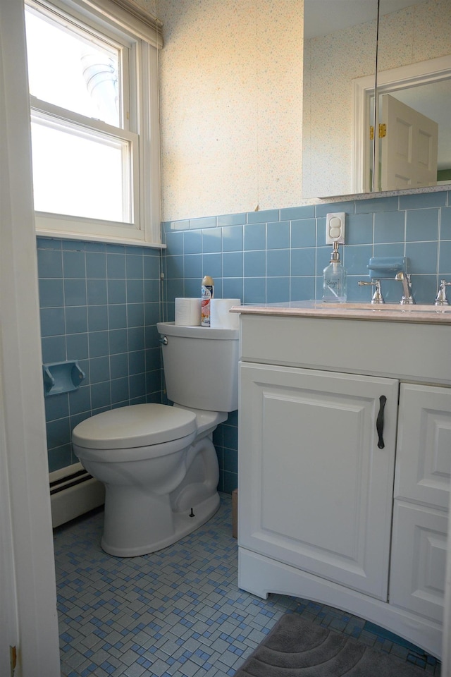 bathroom featuring vanity, a baseboard heating unit, tile walls, and toilet