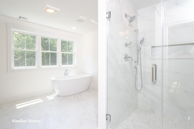 bathroom featuring shower with separate bathtub