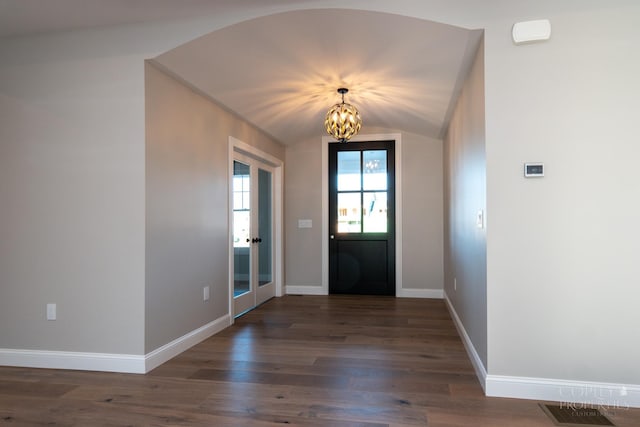 foyer entrance featuring dark hardwood / wood-style floors, vaulted ceiling, and a notable chandelier