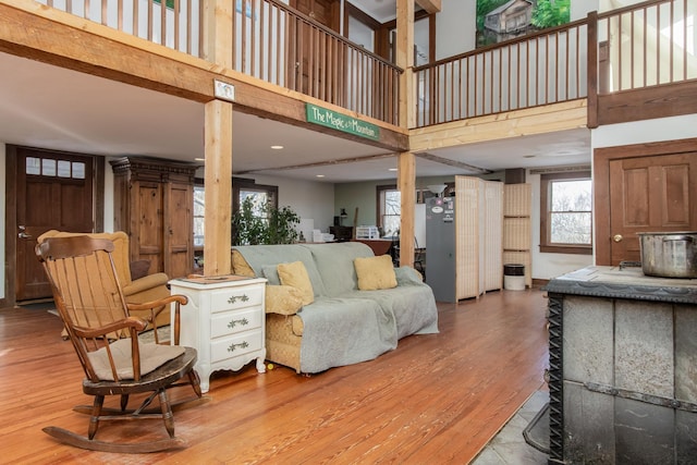 living room featuring a towering ceiling and light wood-type flooring