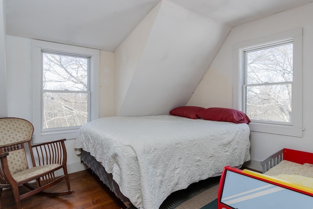 bedroom with vaulted ceiling and dark wood-type flooring