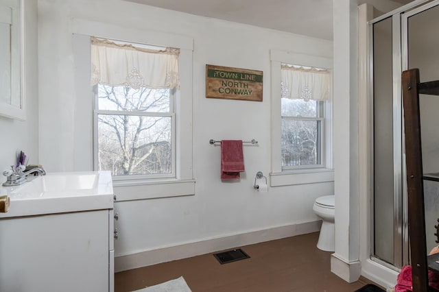 bathroom featuring hardwood / wood-style flooring, vanity, toilet, and an enclosed shower