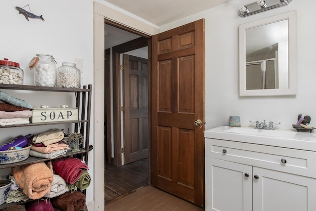 bathroom featuring hardwood / wood-style flooring, vanity, and an enclosed shower