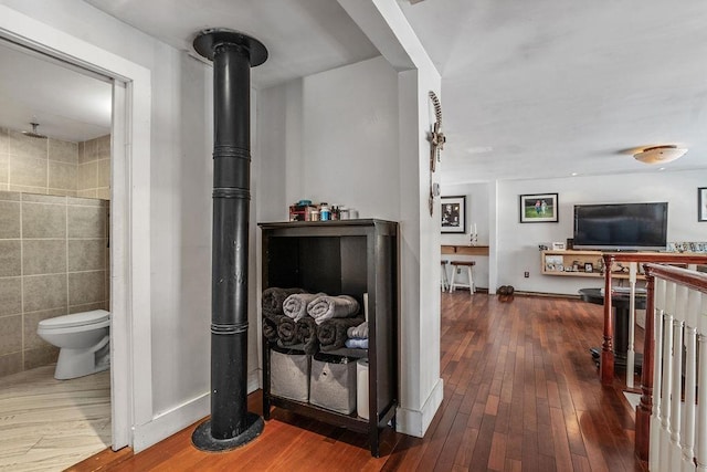 hall featuring dark hardwood / wood-style flooring and tile walls