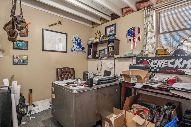 carpeted home office featuring beamed ceiling