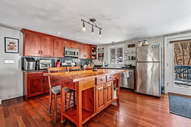 kitchen with stainless steel appliances, butcher block countertops, dark hardwood / wood-style flooring, and decorative backsplash