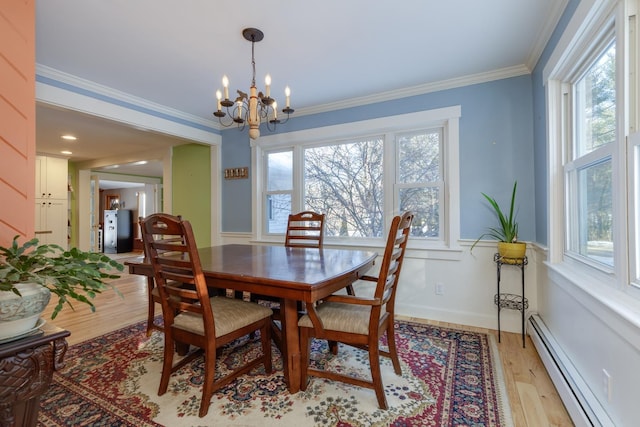 dining space featuring ornamental molding, plenty of natural light, baseboard heating, and light hardwood / wood-style flooring