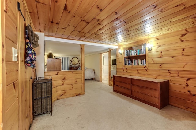 bedroom with light carpet, wood ceiling, and wood walls