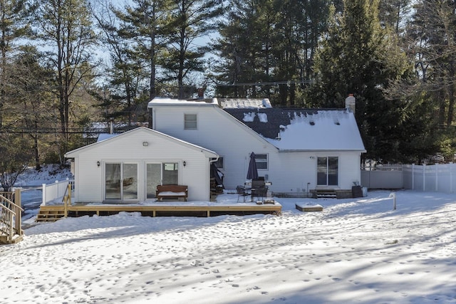 snow covered house featuring a wooden deck