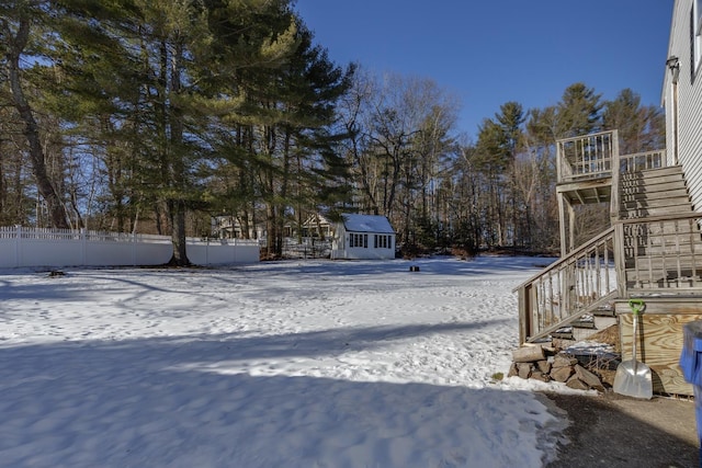 yard layered in snow with a shed