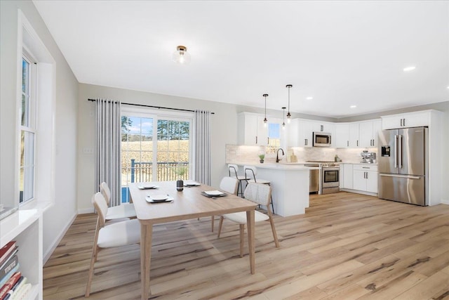 dining space featuring light hardwood / wood-style floors and sink