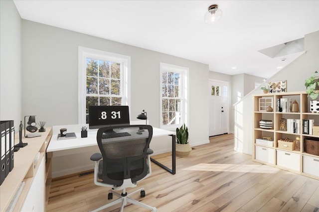 home office with light hardwood / wood-style flooring