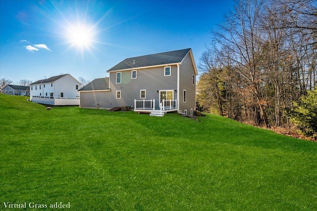 rear view of property featuring a deck and a lawn