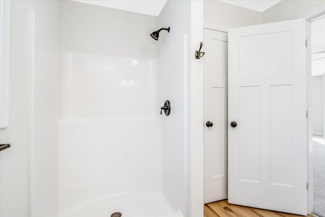 bathroom with walk in shower and wood-type flooring