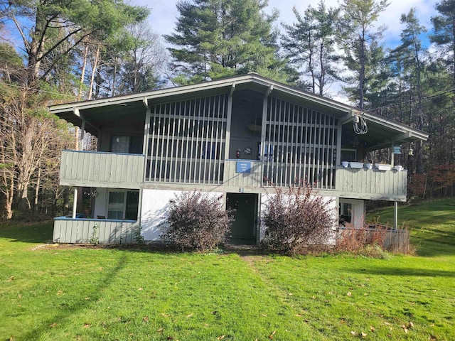 back of house with a yard and a balcony