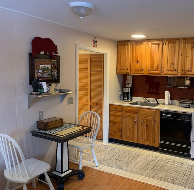 kitchen featuring sink, light hardwood / wood-style flooring, and black appliances