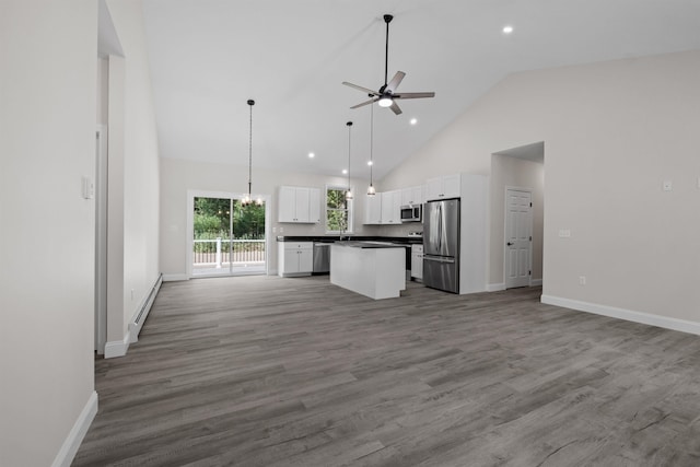 kitchen featuring appliances with stainless steel finishes, hanging light fixtures, a center island, white cabinets, and ceiling fan with notable chandelier